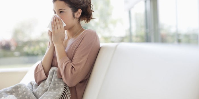 Девушка прикрывает нос платком